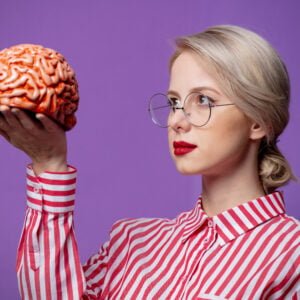 Beautiful woman in red striped shirt hold human brain