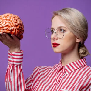 Beautiful woman in red striped shirt hold human brain