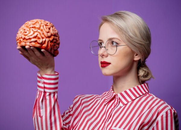 Beautiful woman in red striped shirt hold human brain